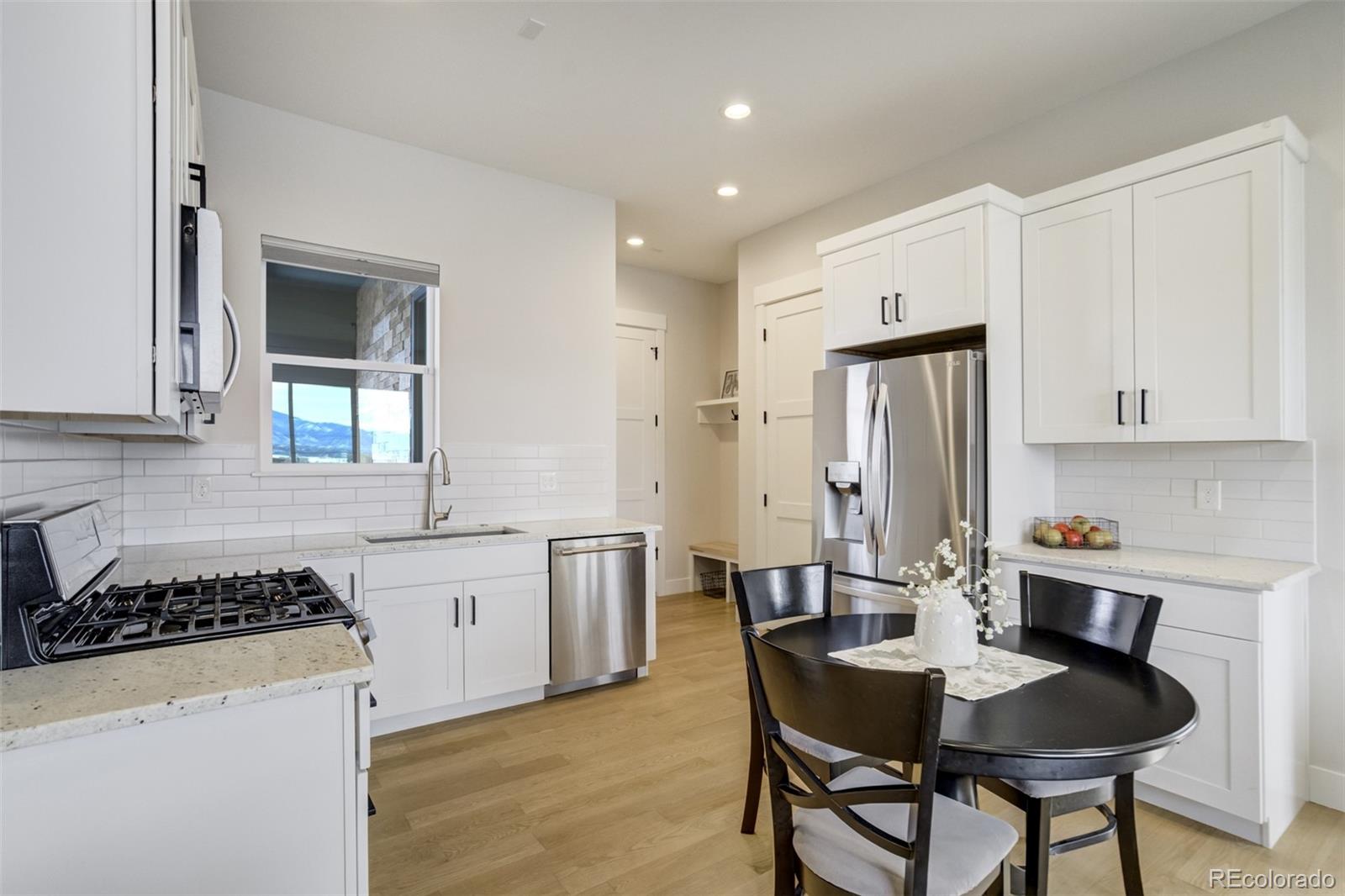 1287 Kelso Place Colorado Springs, CO 80921 - Photo 38 of 50 a kitchen with stainless steel appliances granite countertop a kitchen island a stove a table and chairs
