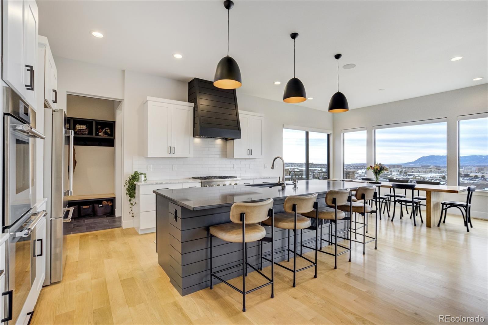 1287 Kelso Place Colorado Springs, CO 80921 - Photo 9 of 50 a kitchen with stainless steel appliances granite countertop a stove top oven a sink a dining table and chairs with wooden floor