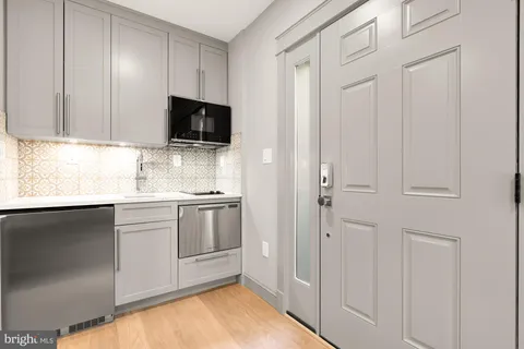a kitchen with stainless steel appliances white cabinets and a refrigerator