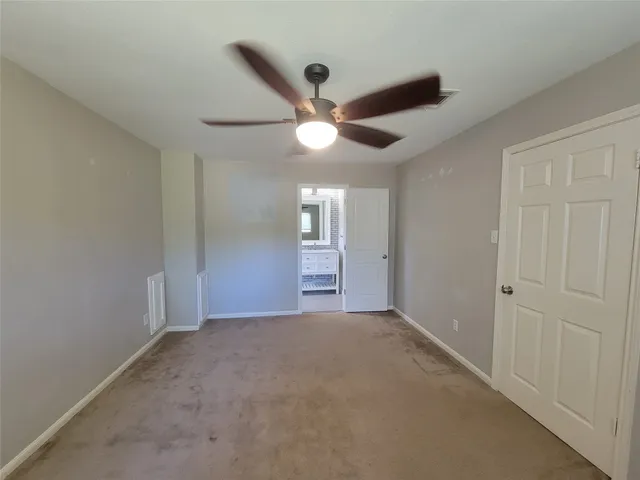 a view of an empty room and a ceiling fan