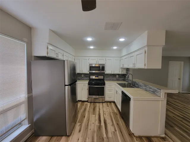 a kitchen with a refrigerator a stove top oven and a counter top space