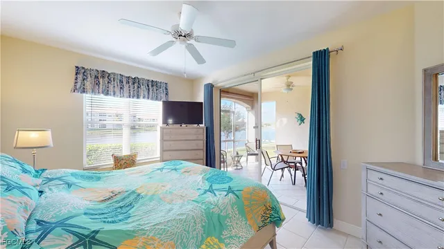 a bedroom with a large bed and a chandelier fan