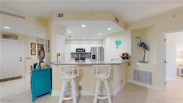 a kitchen with stainless steel appliances kitchen island granite countertop a refrigerator and microwave