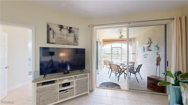 a living room with furniture a flat screen tv and a floor to ceiling window
