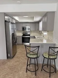 a kitchen with stainless steel appliances kitchen island granite countertop a refrigerator and microwave