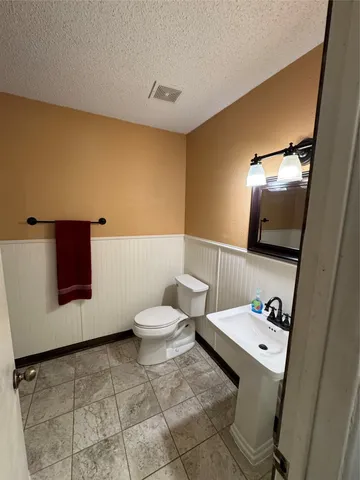 a bathroom with a sink toilet and mirror