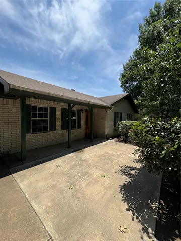 a view of house with backyard and tree in it