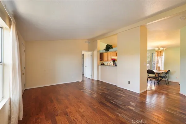 a view of a livingroom with wooden floor and a hallway