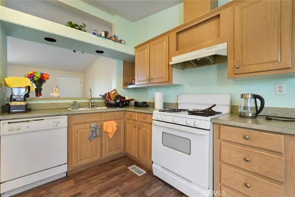 a kitchen with stainless steel appliances granite countertop a sink and cabinets with wooden floor