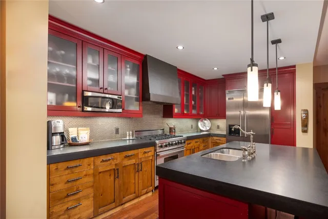 a kitchen with a stove a sink and chairs
