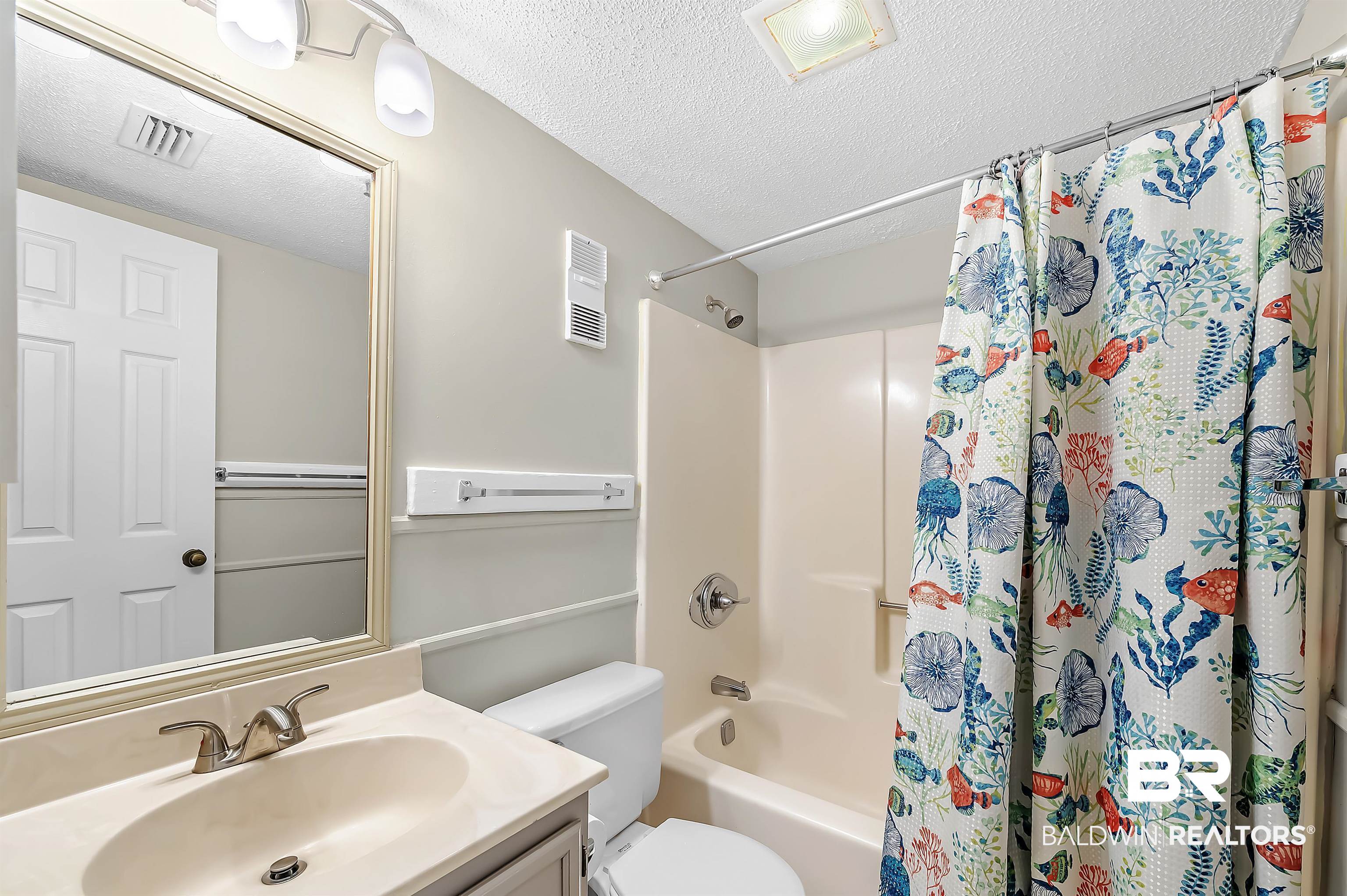 375 Plantation Road, Unit 5409 Gulf Shores, AL 36542 - Photo 26 of 48 Full bathroom with a textured ceiling, toilet, vanity, and shower / tub combo with curtain