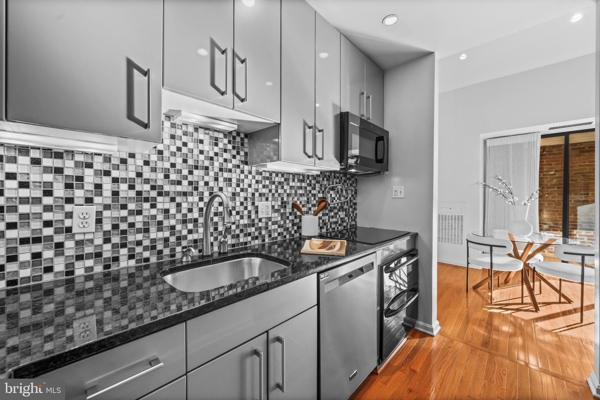 3225 Grace Street Northwest, Unit 219 Washington, DC 20007 - Photo 17 of 45 a kitchen with a sink a stove and cabinets