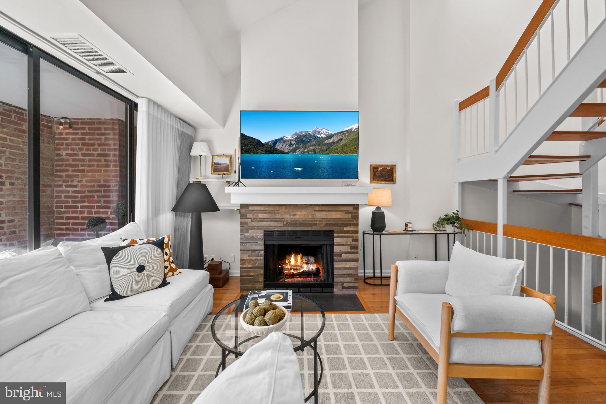 3225 Grace Street Northwest, Unit 219 Washington, DC 20007 - Photo 5 of 45 a living room with furniture and a fireplace