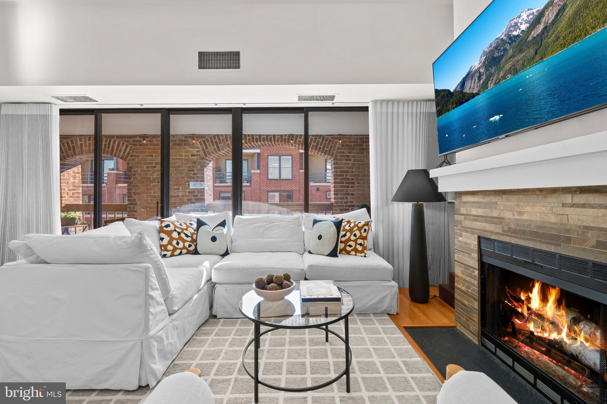 3225 Grace Street Northwest, Unit 219 Washington, DC 20007 - Photo 7 of 45 a living room with furniture a fireplace and a floor to ceiling window