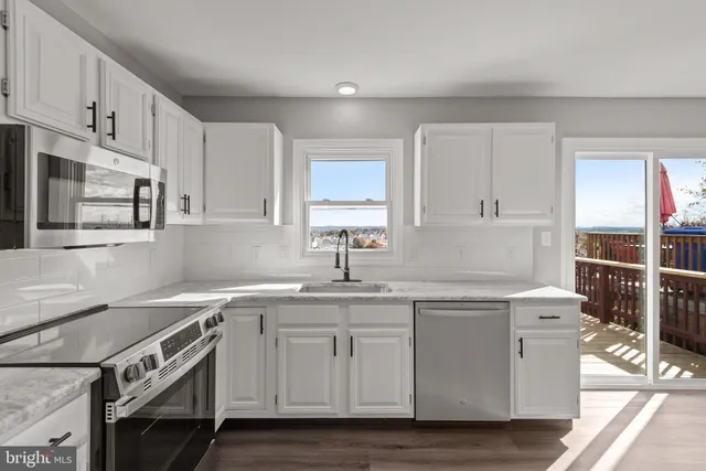 a kitchen with stainless steel appliances granite countertop a sink stove and cabinets
