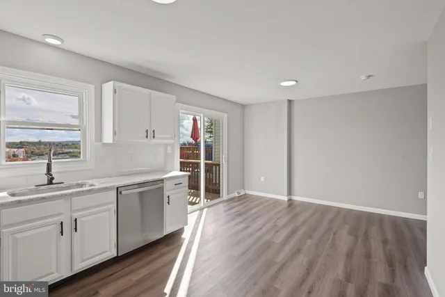 a view of a kitchen with sink and dishwasher with wooden floor