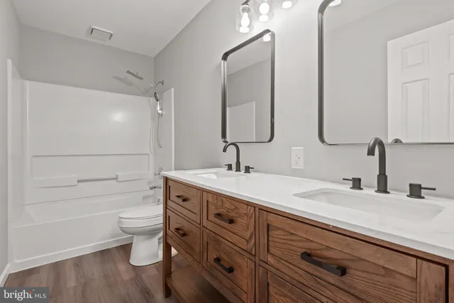a bathroom with a granite countertop sink a toilet and a large mirror