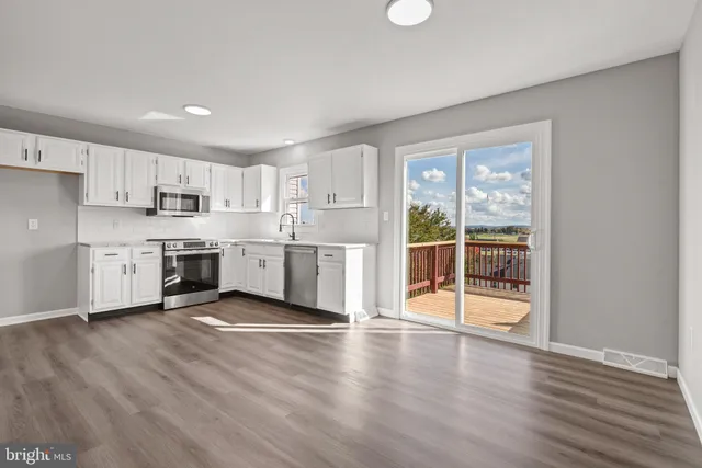 a view of a kitchen with wooden floor and electronic appliances