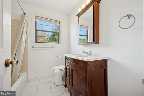 a bathroom with a granite countertop toilet sink and mirror