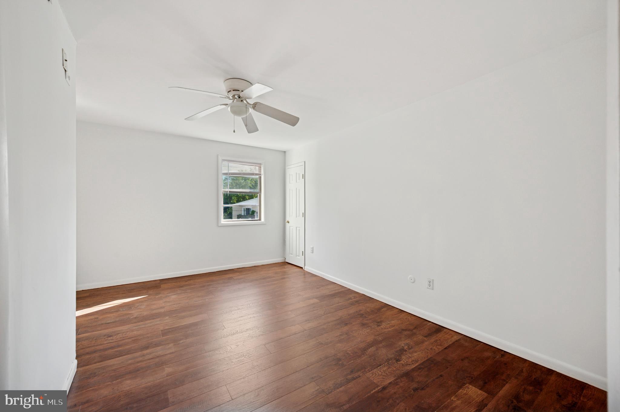 710 Willow Street, Unit B Lansdale, PA 19446 - Photo 25 of 25 an empty room with wooden floor ceiling fan and windows