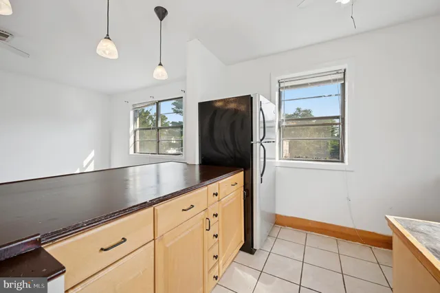 a kitchen with granite countertop white cabinets and refrigerator