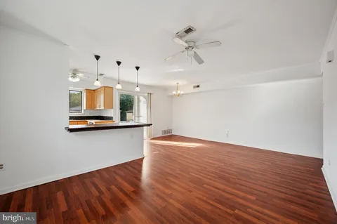a view of a room with wooden floor and ceiling fan