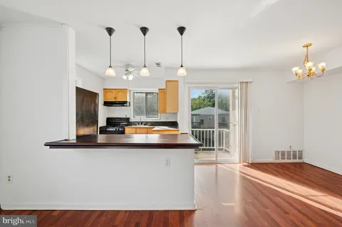 a view of a kitchen with a sink a window and wooden floor