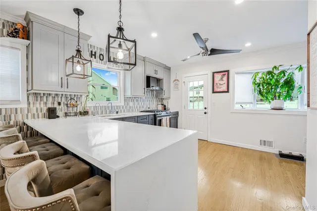 a large kitchen with kitchen island a stove a sink a center island and furniture