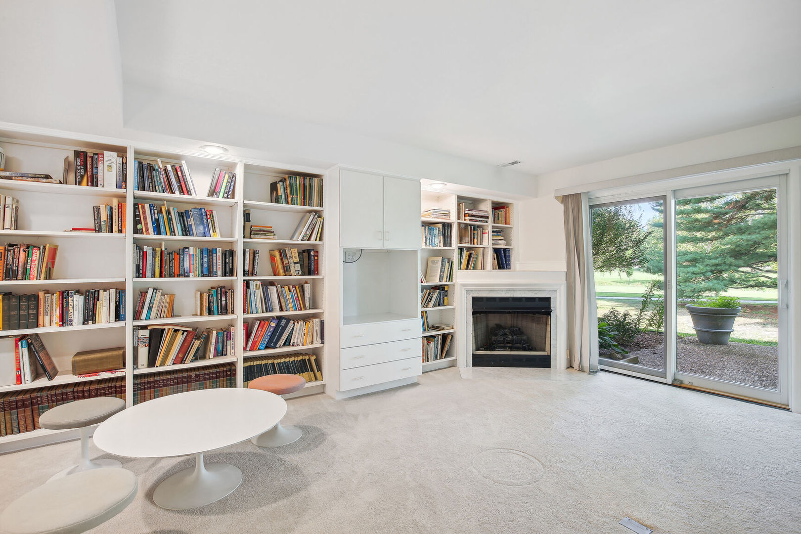 27 Fields East, Unit 27 Champaign, IL 61822 - Photo 25 of 35 a living room with a bookshelf and a fireplace