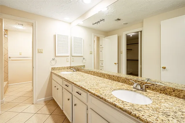 a spacious bathroom with a granite countertop sink and a mirror