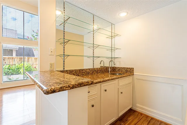 a bathroom with a granite countertop sink and a window