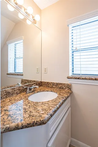 a view of a bathroom with a granite countertop sink and a window