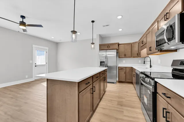 a kitchen with stainless steel appliances granite countertop a sink a stove and a refrigerator