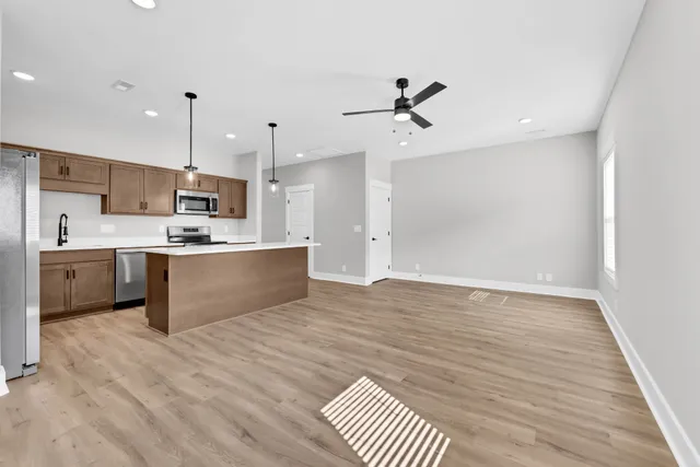 a large kitchen with kitchen island a sink stainless steel appliances and white cabinets