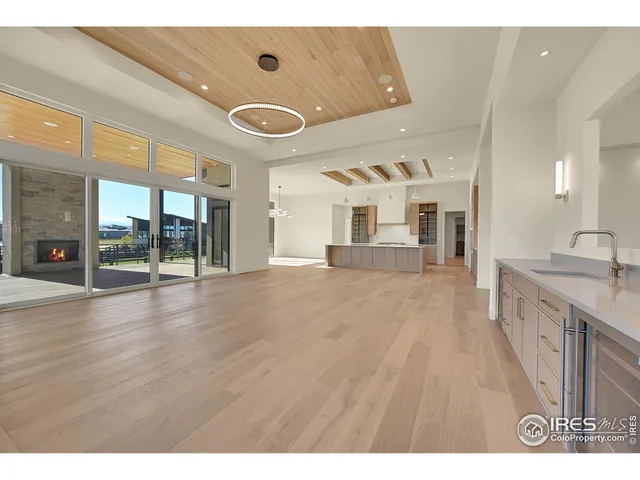 a open kitchen with stainless steel appliances kitchen island a large counter top and a wooden floors