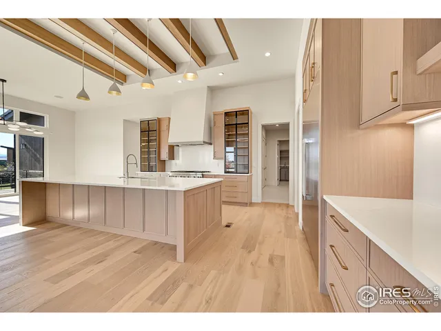 a kitchen with kitchen island granite countertop a sink cabinets and wooden floor