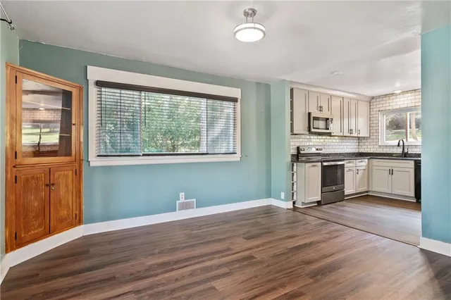 a kitchen with granite countertop wooden floors and stainless steel appliances