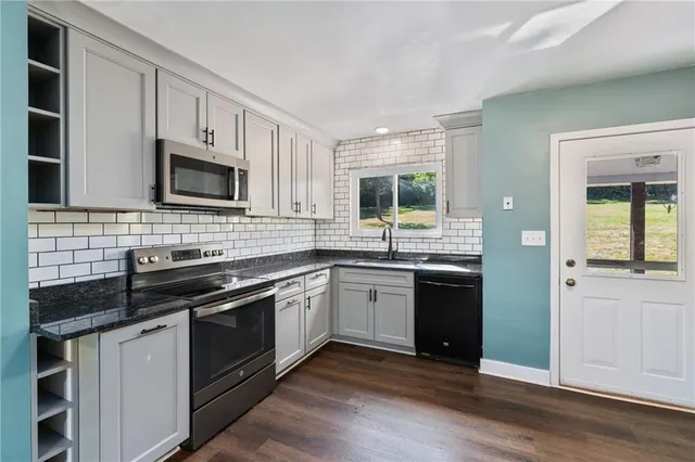a kitchen with a sink stove and microwave