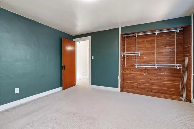 a view of an empty room with wooden floor and windows