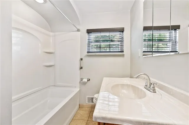 a bathroom with a tub sink and mirror