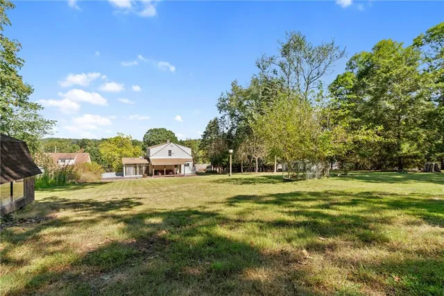 a large yard with lots of green space and seating area
