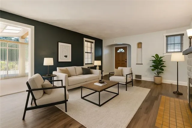 a living room with furniture and a wooden floor