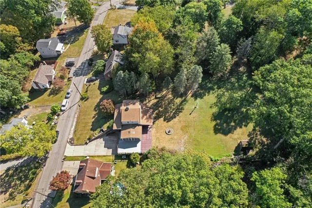 an aerial view of residential house with outdoor space and trees all around