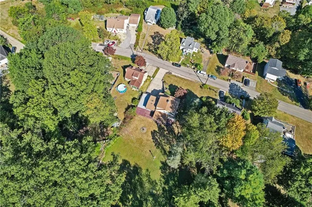 an aerial view of residential house with outdoor space and trees all around