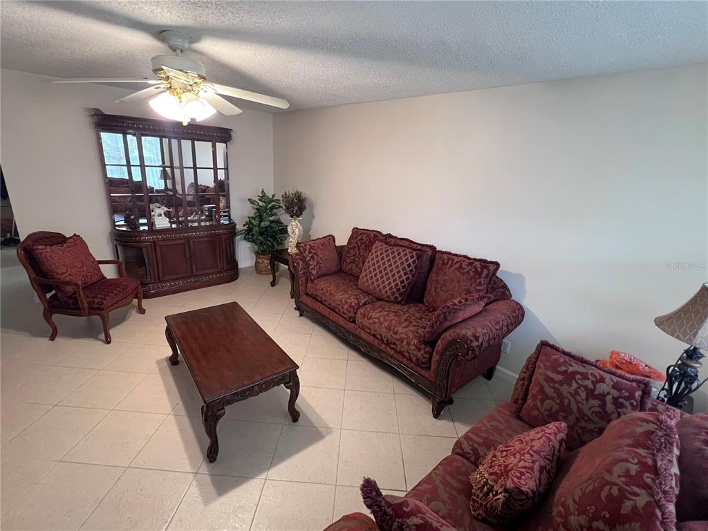 240 Northampton L, Unit 240 West Palm Beach, FL 33417 - Photo 5 of 11 a living room with furniture and a large mirror