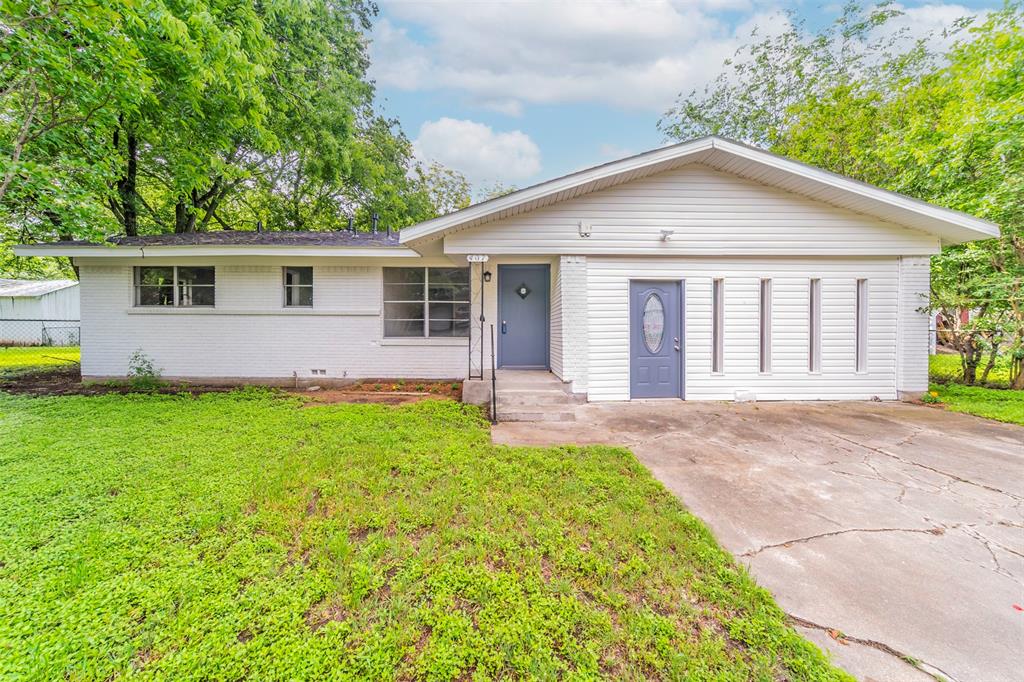 a view of a house with a yard and potted plants