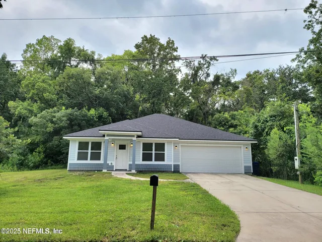 a front view of a house with a garden