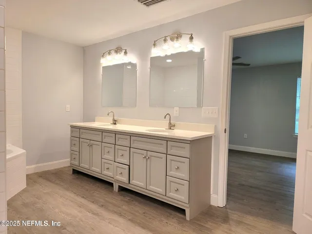 a bathroom with a sink a mirror and a bathtub