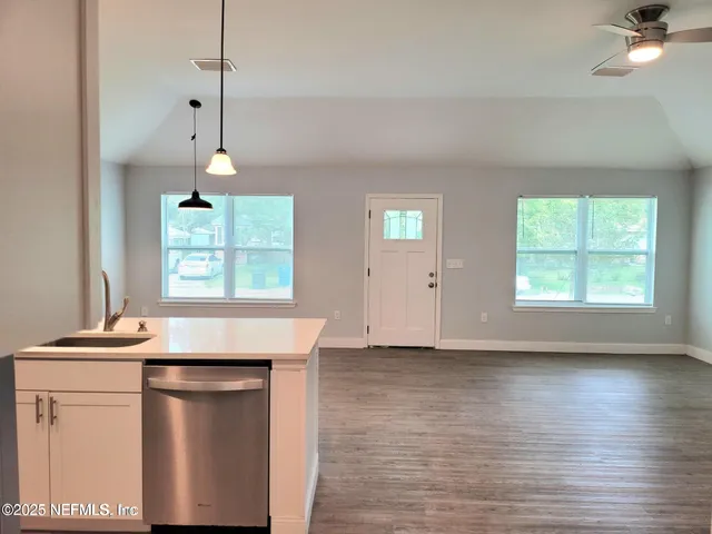 a kitchen with kitchen island a stove a sink and a window