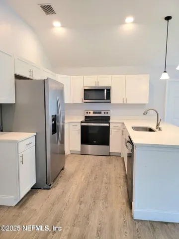 a kitchen with stainless steel appliances a stove a sink and a refrigerator